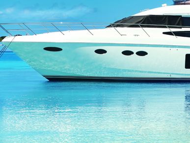 Luxury yacht floating on clear turquoise water under a blue sky.