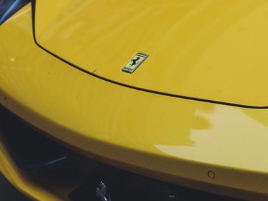 Close-up of a yellow Ferrari hood with the emblem.