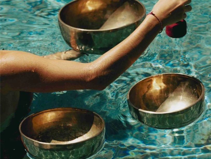 Personne tenant un bol chantant dans une piscine.