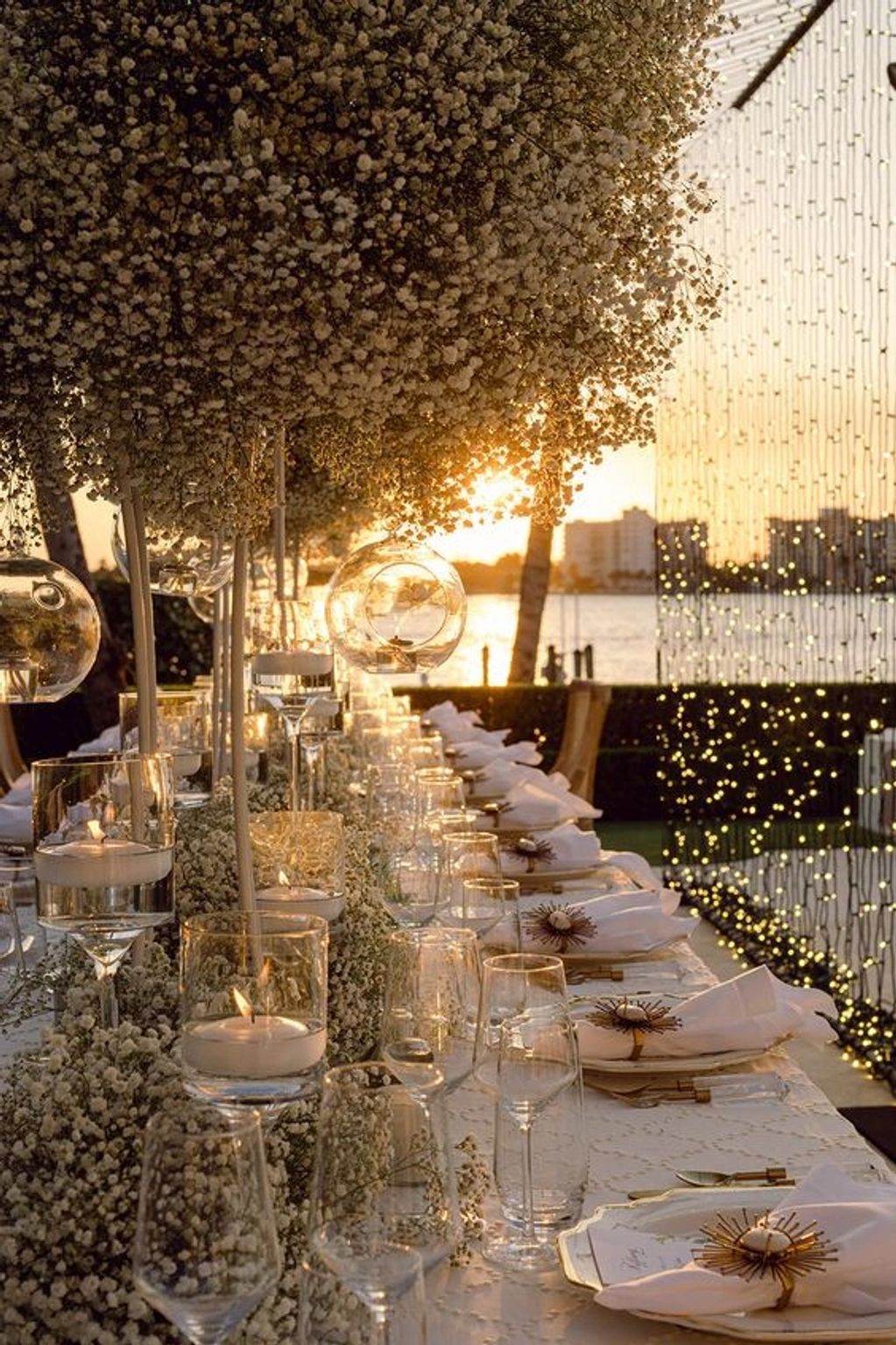 Table élégamment décorée au coucher du soleil avec fleurs et bougies.