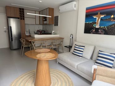 Modern open-plan living room with kitchen and cozy seating area.