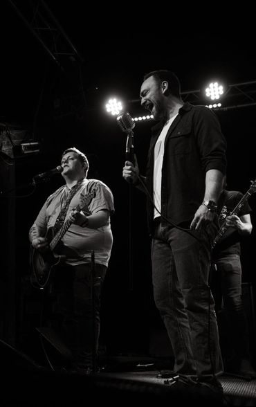 Black and white photo of a passionate band performing on stage.