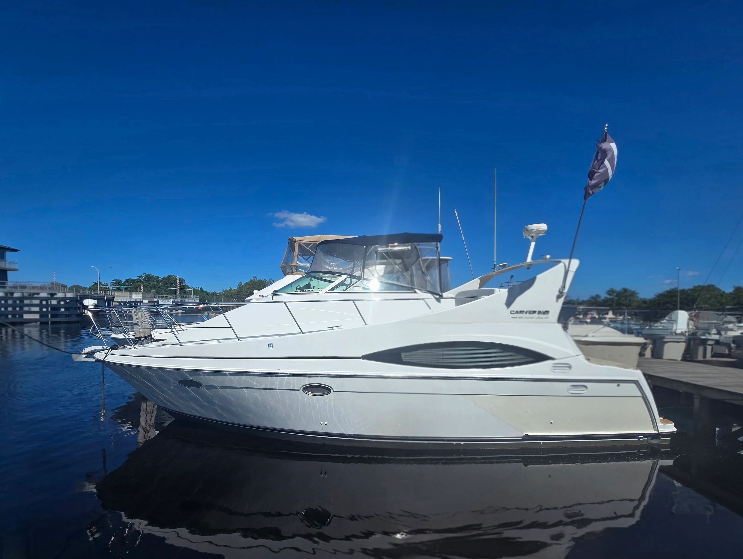 White yacht docked under clear blue sky.