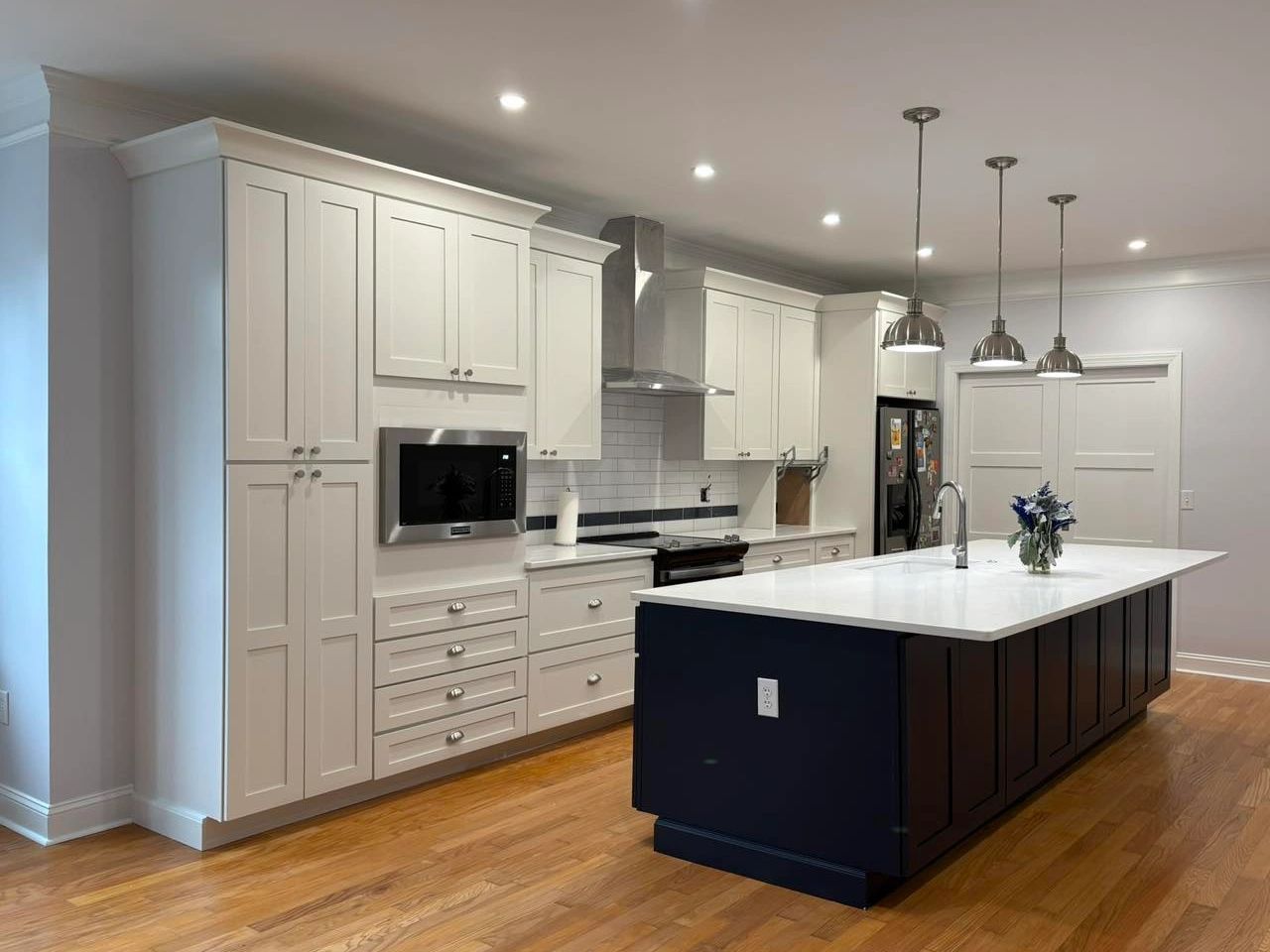 Modern kitchen with white cabinets and a dark island.