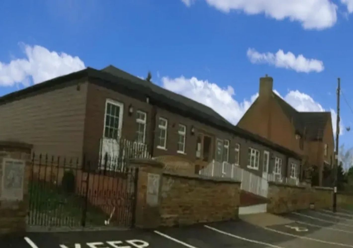 A row of single-story brick buildings under a blue sky.