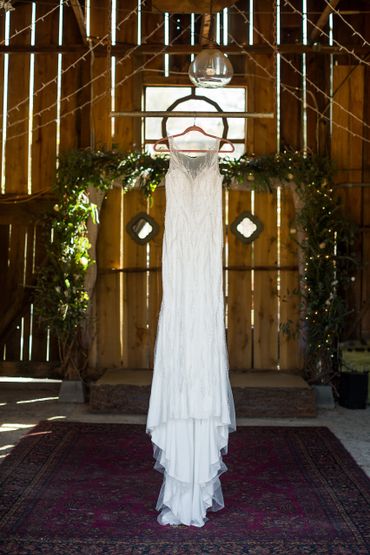 A wedding gown on a hanger in a room 