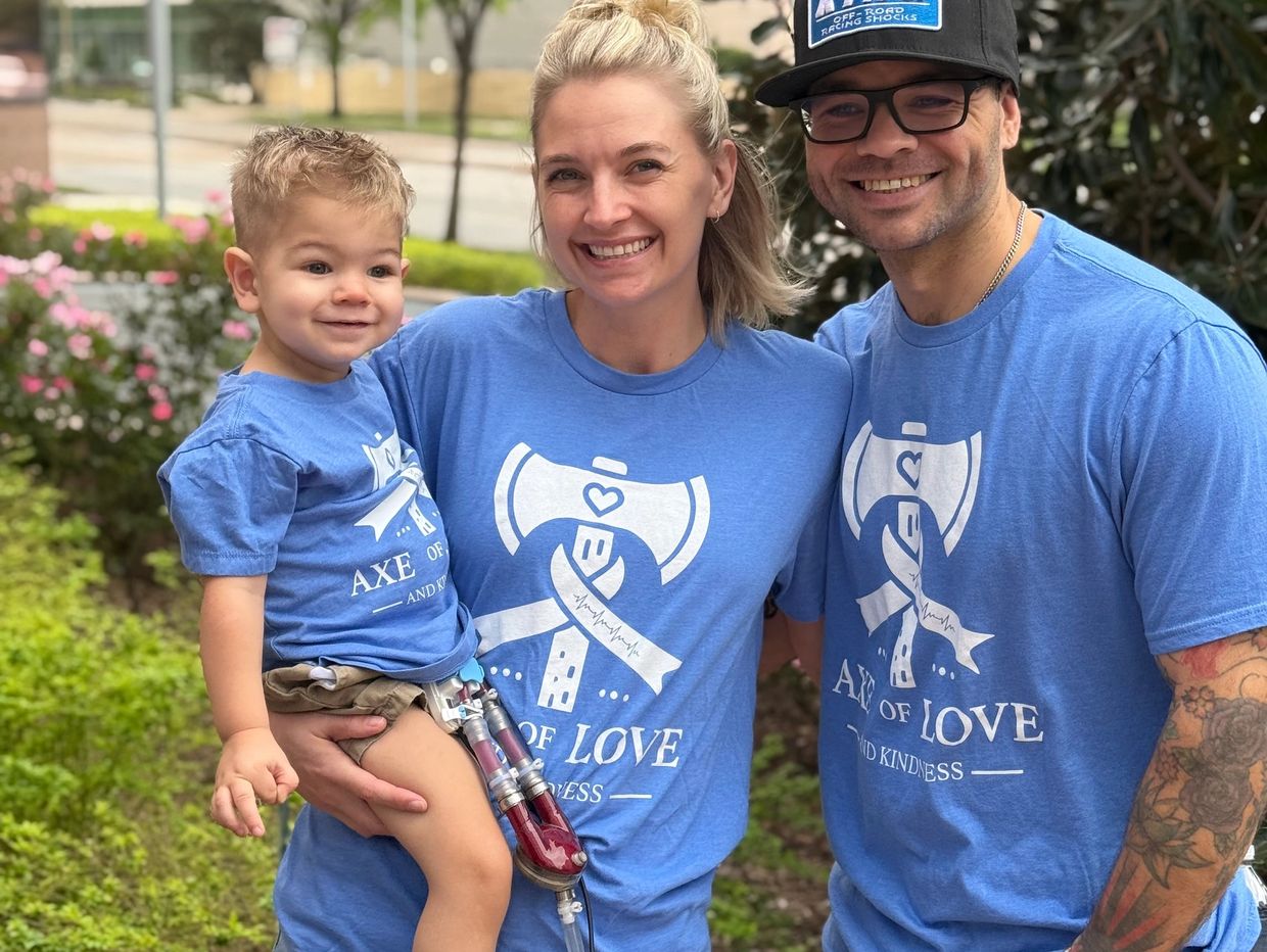 Family in matching shirts with a young child who has a prosthetic leg.