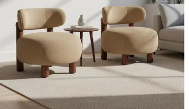 Two beige cushioned chairs with a small round table between them.