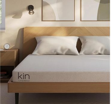 Modern bedroom with wooden bed frame and neutral bedding.