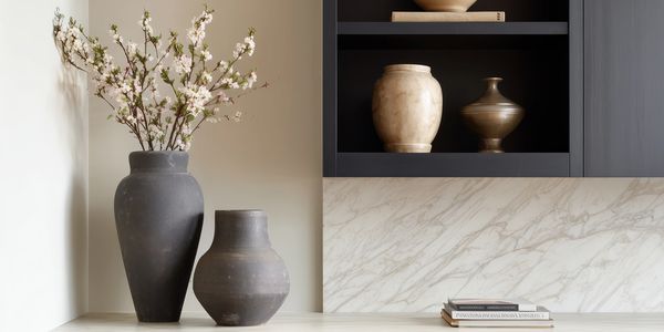 Minimalist kitchen decor with vases and marble backsplash.
