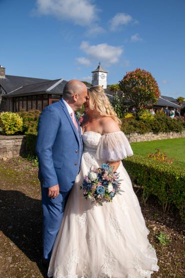 Bride and groom share a joyful moment outdoors on their wedding day.