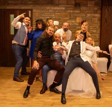 Group of friends having fun at a party, posing with props and smiles.