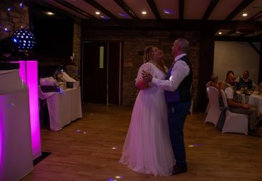 A bride and groom share a dance at their wedding reception.