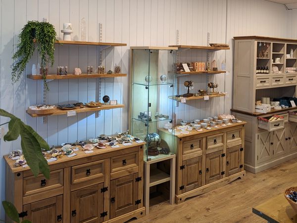 Wooden shelves and cabinets with crystals, candles and singing bowls.