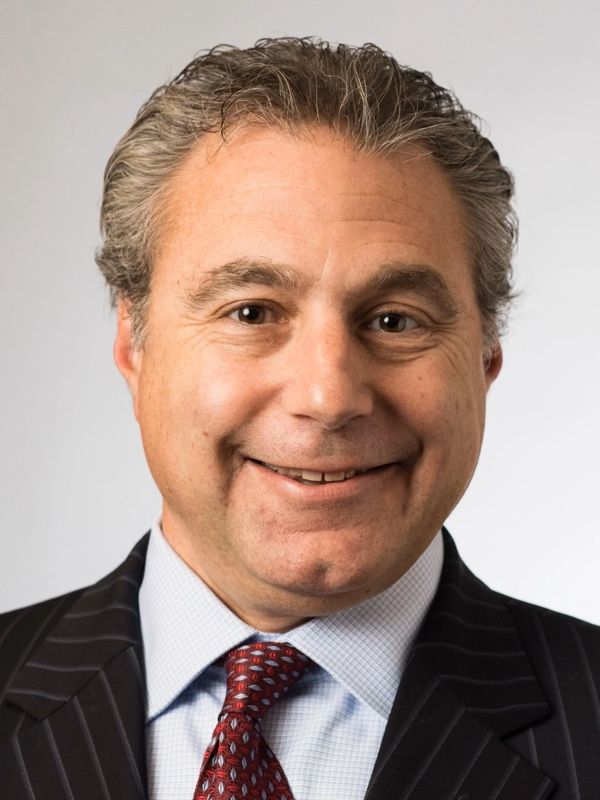 Smiling man in suit and tie.