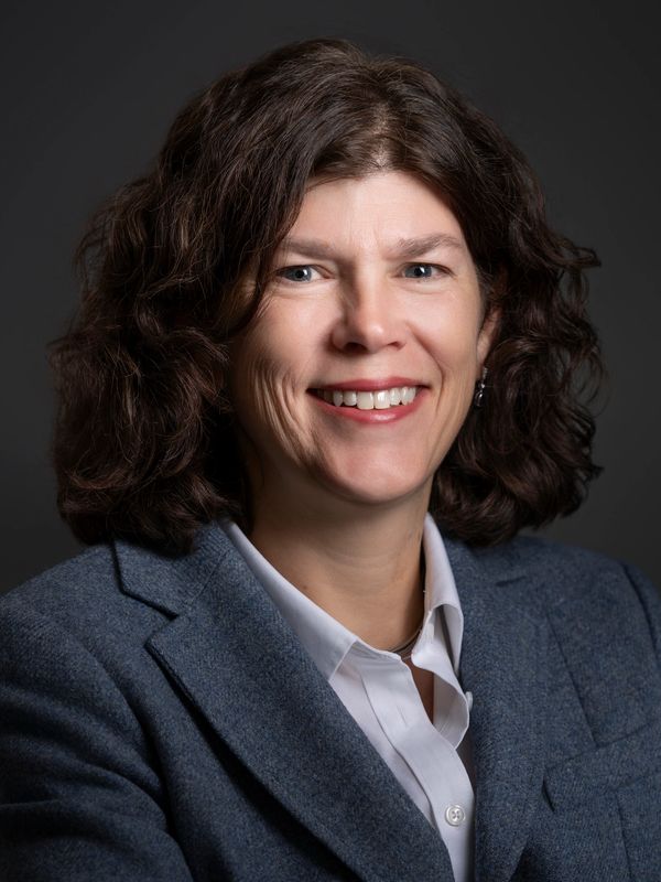 Professional woman smiling in a blazer.
