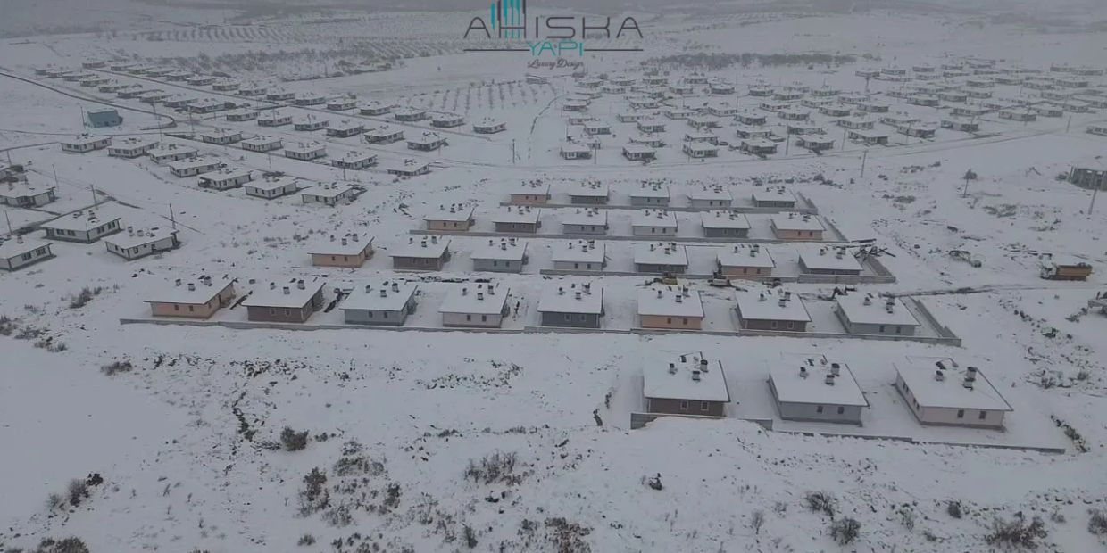 Karla kaplı geniş bir konut alanının hava görüntüsü.