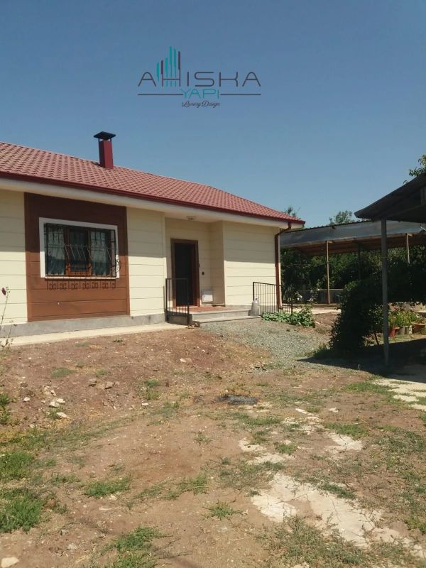 Kırmızı çatılı küçük tek katlı ev.
