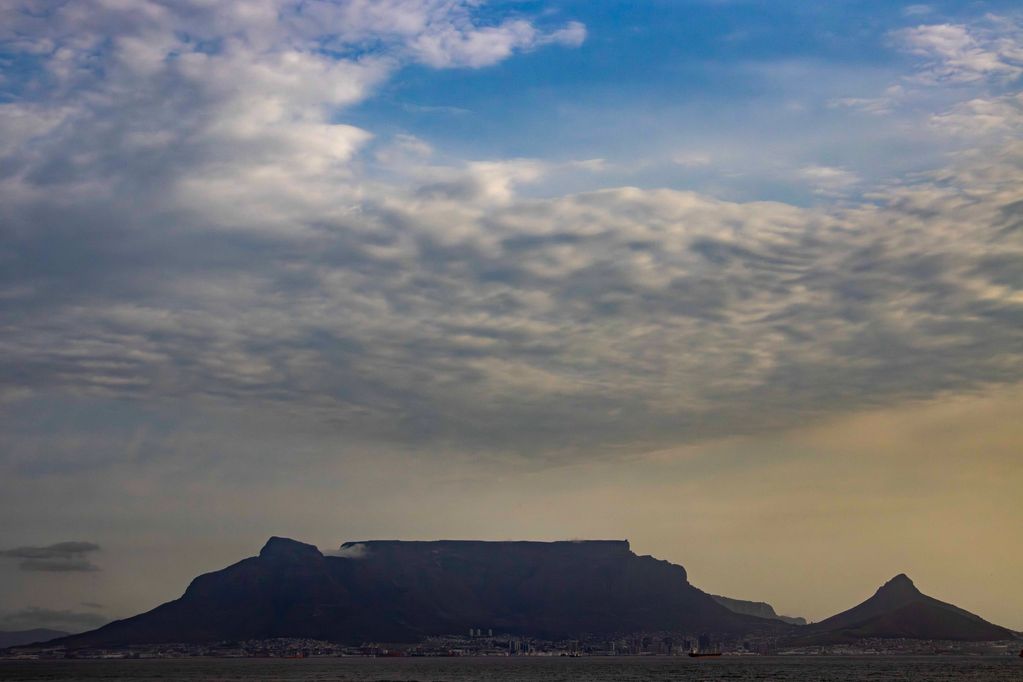Table Mountain with dramatic cloud cover over Cape Town at dusk.