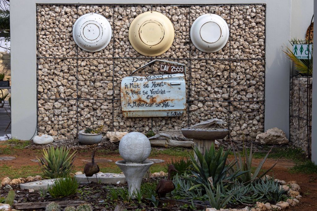 Decorative garden wall with vintage car door and enamel plates.