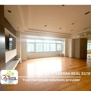 Bright empty room with wooden floor and large windows.