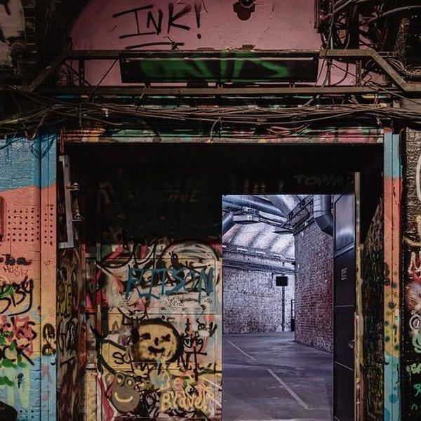 Graffiti-covered entrance reveals an industrial space inside.