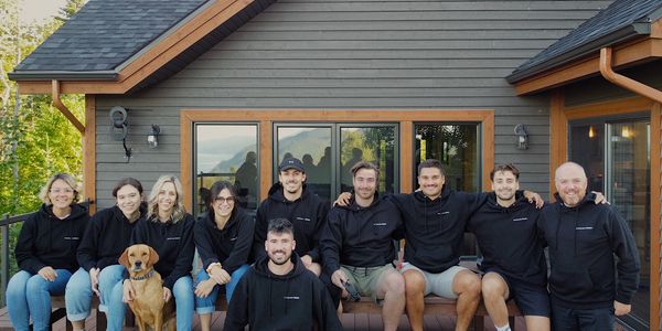 Groupe de personnes sur la terrasse d'un chalet.