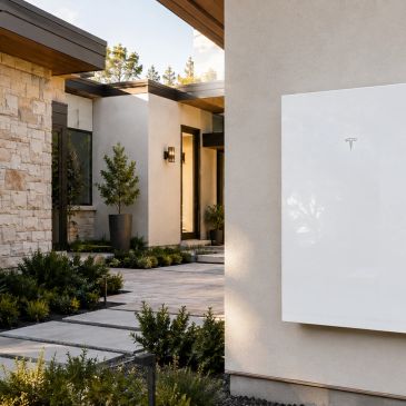 Tesla Powerwall installed on a modern house exterior.