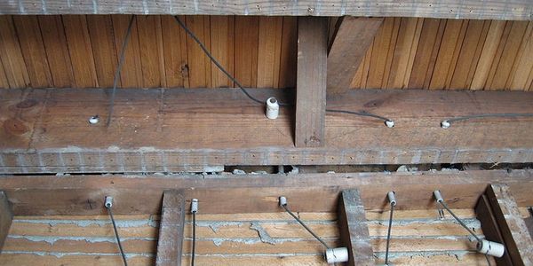 An electrician replacing an old knob and tube wiring system to a newer electrical system.