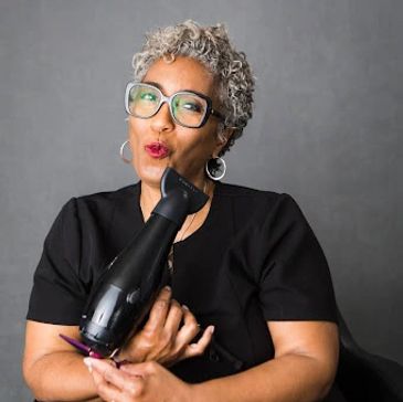 Tracy J. Moss holding blow dryer and blowing the heat from it