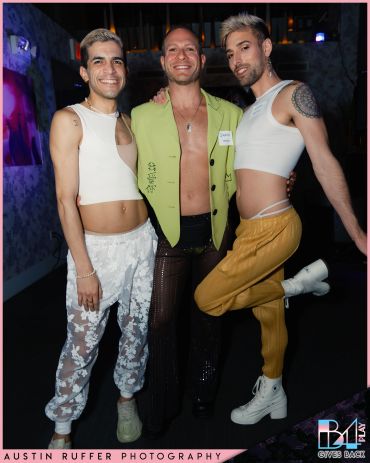 Three stylish individuals pose confidently at a nighttime event, showcasing bold and unique fashion.