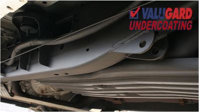 Close-up of a car's undercarriage showing clean undercoating with Valugard branding.