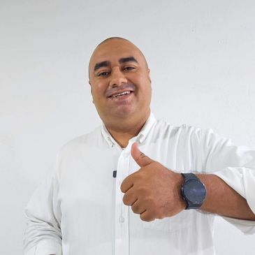 Man smiling and giving a thumbs up gesture.