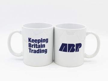 Two white mugs with 'Keeping Britain Trading' and 'ABP' logos.