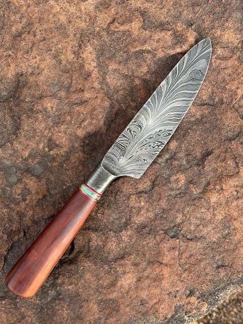 Sharp cooking knife featuring Damascus steel and wood.

