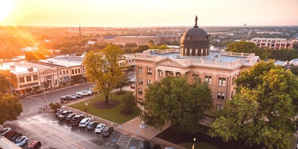 A historic courthouse bathed in warm sunset light in a small town.
