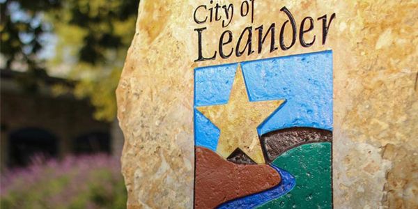 Stone monument with City of Leander emblem and star symbol.