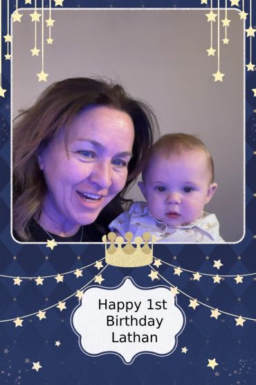 A woman celebrates Lathan's 1st birthday with a baby photo frame.