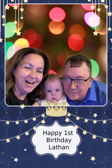 Family celebrating Lathan's 1st birthday with colorful lights.