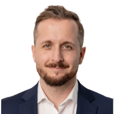 Porträt eines lächelnden Mannes im Anzug.