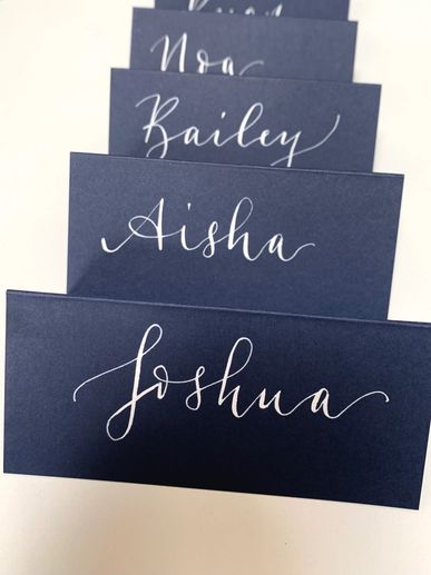 Navy blue, folded name place cards with white calligraphy names