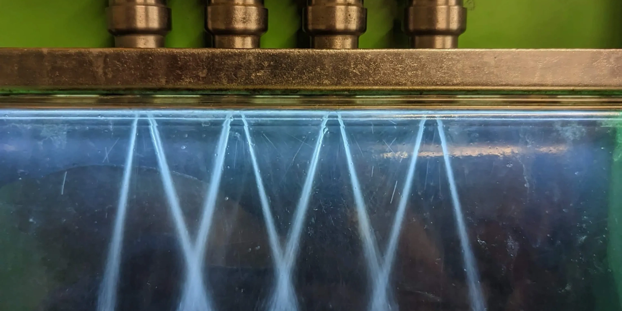 Close-up of water jets spraying from metallic nozzles.
