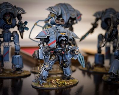 Detailed blue robotic warrior miniatures with weapons on display.