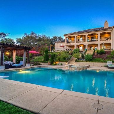 Luxurious house with a large pool and outdoor seating area.