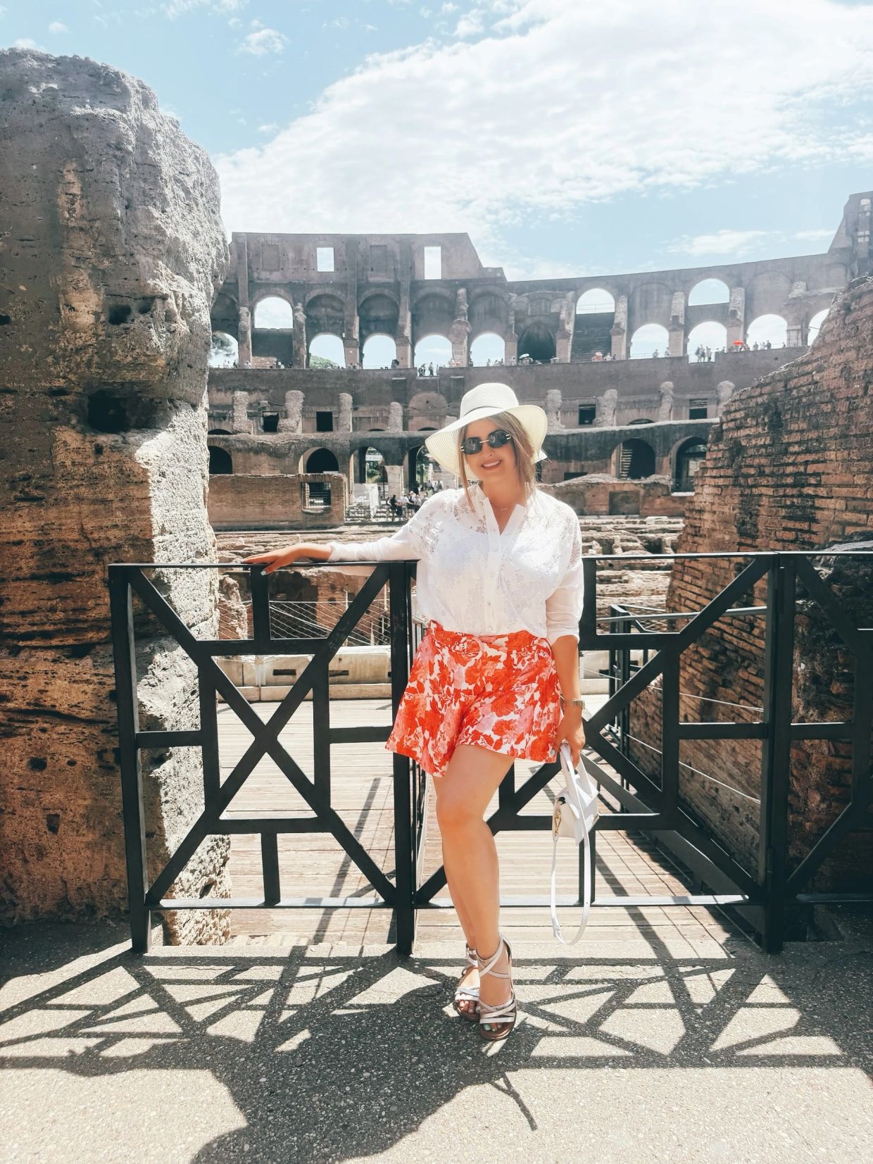 Woman posing at the Colosseum in Rome on a sunny day.