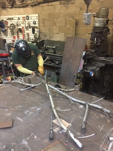 men working on silver metal thing