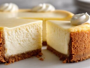 Creamy cheesecake with a graham cracker crust and whipped cream topping.