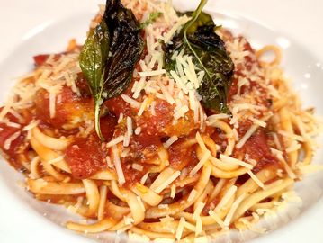 Chicken & beef meat balls, spaghetti pasta, marinera sauce, and parmesan cheese.
