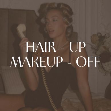 Woman with hair up and no makeup, holding a phone.