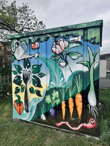 Colorful garden-themed mural with vegetables and gardening tools.